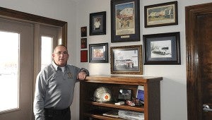 Carriere Volunteer Fire Department Chief Chris Banks stands with the photos and memorabilia of the department history. The department was started in 1972.  Photo by Alexandra Hedrick