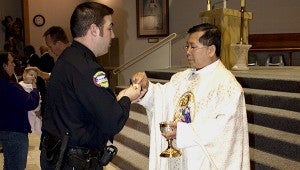 Holy communion: Picayune Police officer Chris Wagner receives holy communion from Father Joseph Truong Trinh. Jodi Marze | Picayune Item