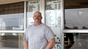 Tim Kellar stands in front his menu and current pricing. The third-generation owner says his philosophy is offering good food and prices the community can afford.  Jodi Marze | Picayune Item 