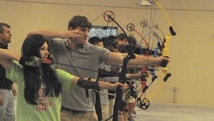 AIM AND FIRE: Students on the Picayune High School Archery competition team finds their target and prepares to fire at targets at practice on Thursday at the Picayune High School Community Safe Room. 