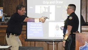 Get a grip: From left: Picayune Police Department Capt. James Bolton demonstrates to the class the proper way to draw and grip their weapons while Patrolman Marcus Whitfield explains the techniques Bolton is using.  Jodi Marze | Picayune Item
