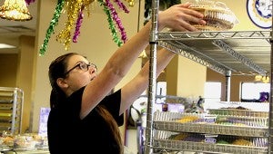 Goodness Galore: Paul’s Pastry employee Alyssa Frierson stacks freshly made king cakes for store customers as thousands are being loaded out back in a container for shipping around the United States. Crews worked through out the night to have  enough of the Mardi Gras staple to meet customer demand. Jodi Marze | Picayune Item 