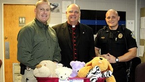 FOR THE CHILDREN:  Canon Jon Filkins continues his efforts to collect stuffed animals to distribute to children in crisis through the Picayune Police Department. Shown from left are Picayune Police Chief Bryan Dawsey, Canon Jon Filkins and Lt. Daniel Davis. Jodi Marze | Picayune Item