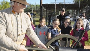 LOADING: Pearl River Central Upper Elementary fourth graders watch as Daryl Ladner, a member of the Seven Stars Artillery re-enactment group, loads the cannon with four ounces of black powder.  Photo by Alexandra Hedrick 