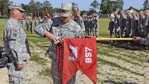 LOCAL UNIT HONORED: Capt. Shan M. Seymour, the unit's commander, attaches the Meritorious Unit Commendation streamer embroidered "Afghanistan 2012-2013" to the Picayune-based 857th Engineer Company's flag during a ceremony at Camp Shelby, Miss.  The unit served in Afghanistan from July 15, 2012 to May 13, 2013, training Afghan National Army engineers. Photo submitted 