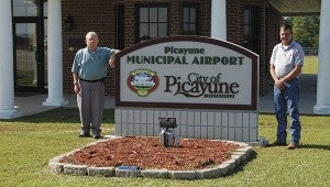 PICAYUNE MUNICIPAL AIRPORT: From left Airport Manager Andy Greenwood and Airport Board member Frank Ford stand in front of the facility that was the first in the state to be built by FAA grand funds. Jodi Marze | Picayune Item