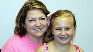 HELPING HANDS: Cecillia Byrd Richards and her daughter Aubrey pull together as a family as they work on the Bac Pac program with Cecillia's mother and other volunteers.  Jodi Marze | Item photo