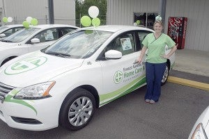 NEW CAR: Hayley Wells poses in front of her brand new work vehicle. She and other registered nurses who work for Forrest General Home Care and Hospice will be delivering their healthcare services using these 2014 Nissan Sentras. Photo by Jeremy Pittari